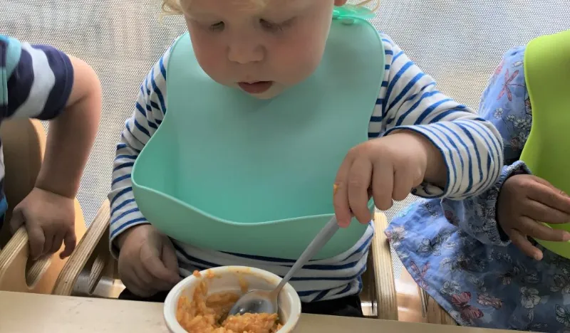 child eating with bib on